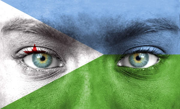 Menselijk gezicht beschilderd met vlag van djibouti — Stockfoto