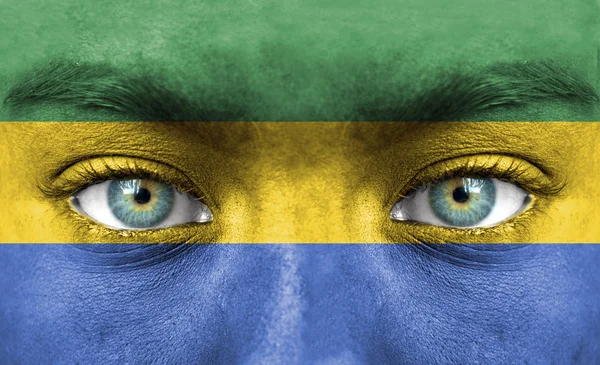 Visage humain peint avec le drapeau du Gabon — Photo