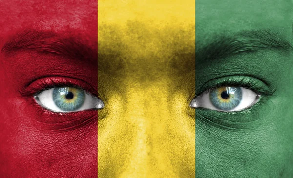 Human face painted with flag of Guinea — Stock Photo, Image