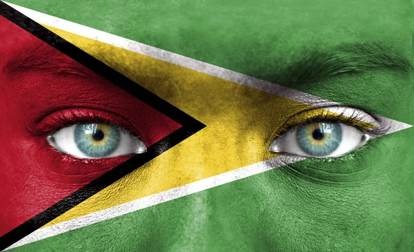 Menschengesicht mit Flagge aus Guyana bemalt — Stockfoto