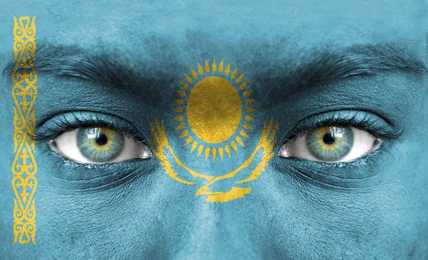 Mänskligt ansikte målade med flagga Kazakstan — Stockfoto