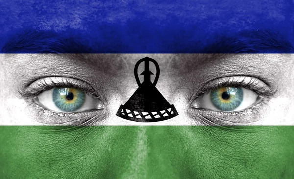 Menschengesicht mit Lesotho-Fahne bemalt — Stockfoto