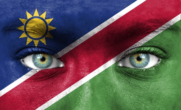 Menschengesicht mit namibischer Flagge bemalt — Stockfoto