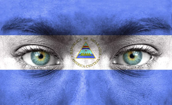 Human face painted with flag of Nicaragua — Stock Photo, Image