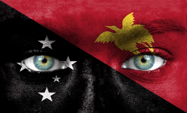 Человеческое лицо, нарисованное флагом Папуа - Новой Гвинеи — стоковое фото