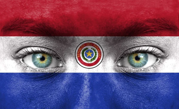 Menselijk gezicht beschilderd met vlag van paraguay — Stockfoto