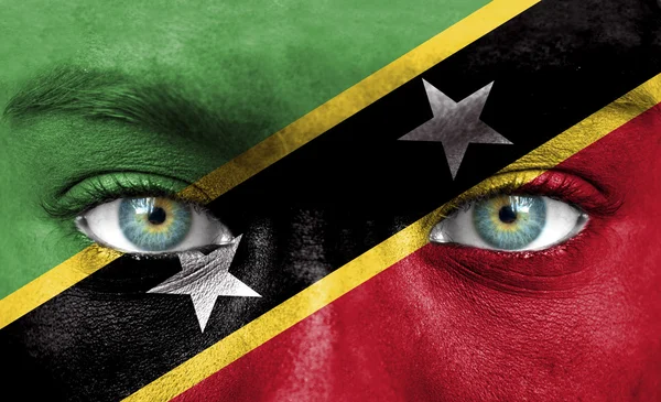 Menschengesicht bemalt mit Flagge der Heiligen Kitts und Nevis — Stockfoto