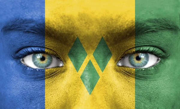 Human face painted with flag of Saint Vincent and the Grenadines — Stock Photo, Image