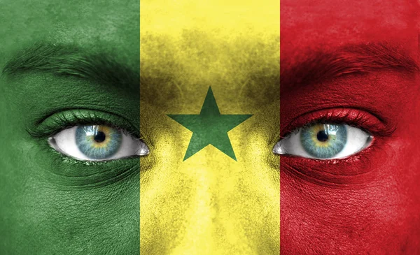 Rosto humano pintado com bandeira do Senegal — Fotografia de Stock