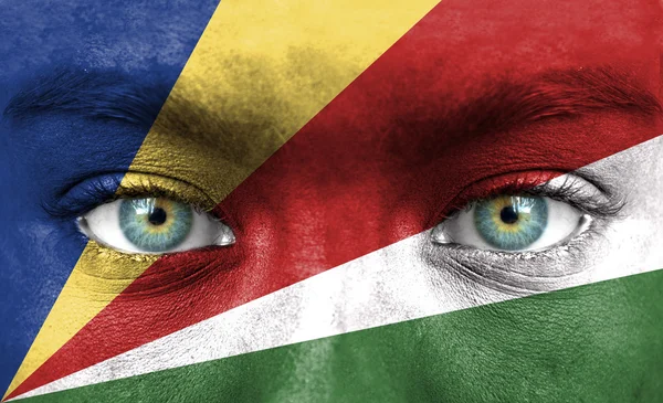 Human face painted with flag of Seychelles — Stock Photo, Image