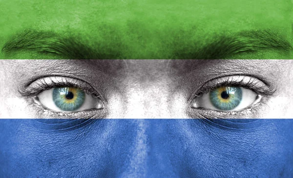 Visage humain peint avec le drapeau de Sierra Leone — Photo