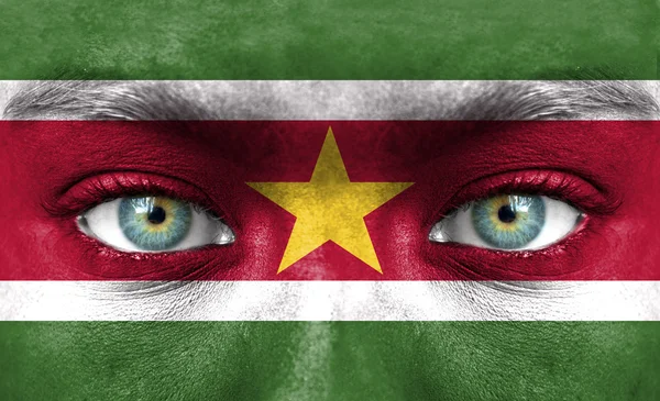 Rosto humano pintado com bandeira do Suriname — Fotografia de Stock