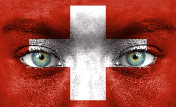 Emberi arcot festett Svájc zászlaja — Stock Fotó