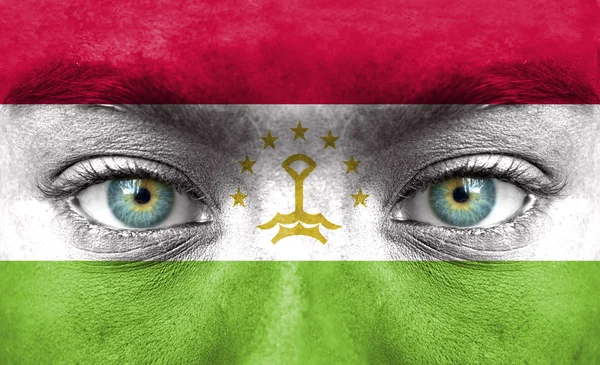 Rosto humano pintado com bandeira do Tajiquistão — Fotografia de Stock