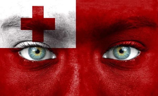 Emberi arcot festett Tonga zászlaja — Stock Fotó