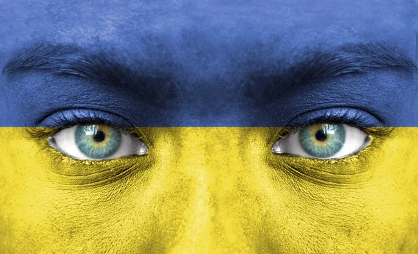 Menselijk gezicht beschilderd met vlag van Oekraïne — Stockfoto