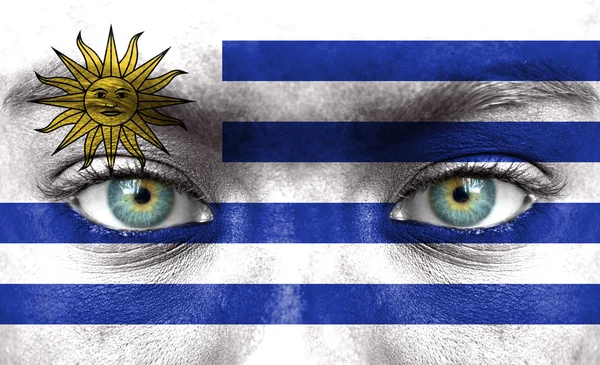 Human face painted with flag of Uruguay — Stock Photo, Image