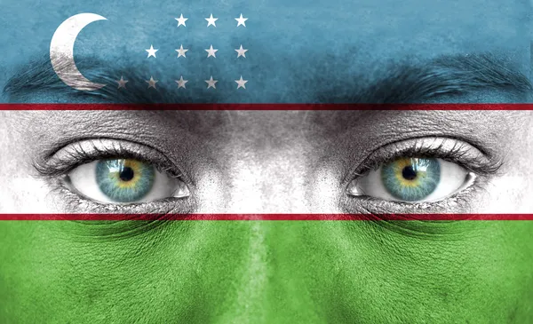 Visage humain peint avec le drapeau de l'Ouzbékistan — Photo