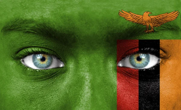 Menschengesicht mit der Flagge Sambias bemalt — Stockfoto