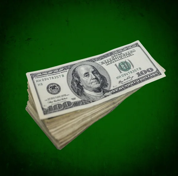 Stack of dollars on grunge green background — Stock Photo, Image