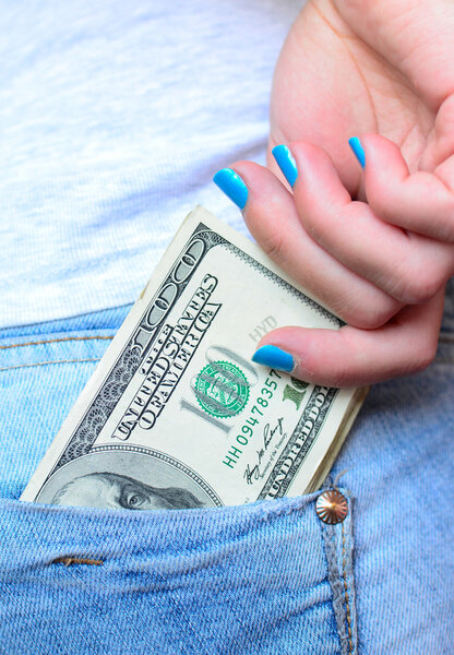 Woman hand taking money from jeans back pocket