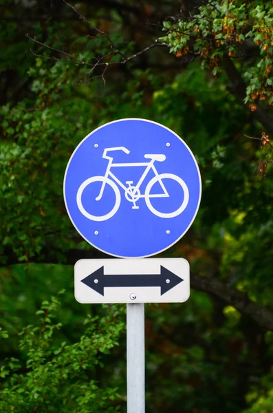 Bicycle sign in park with arrow in both directions — Stock Photo, Image