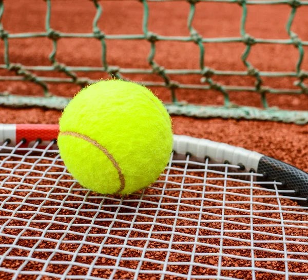 Raquette de tennis avec balle dessus argile sur terrain d'argile — Photo