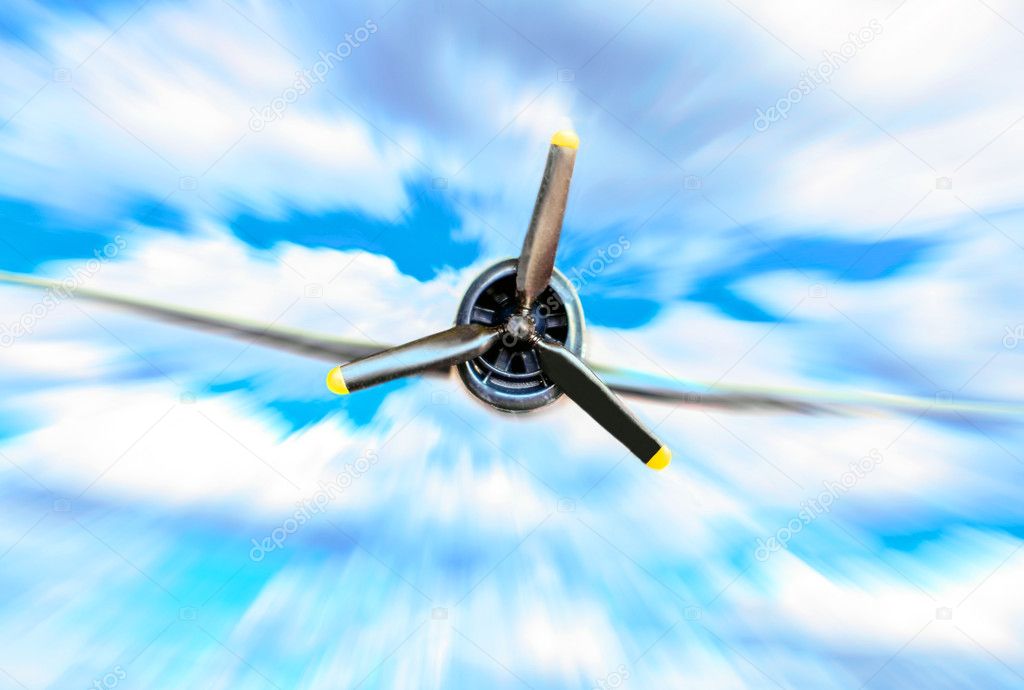 Single propeller fighter plane against blue sky in motion blur