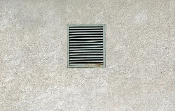 राखाडी भिंत वर जुन्या धातू रस्सी वायुवीजन विंडो . — स्टॉक फोटो, इमेज