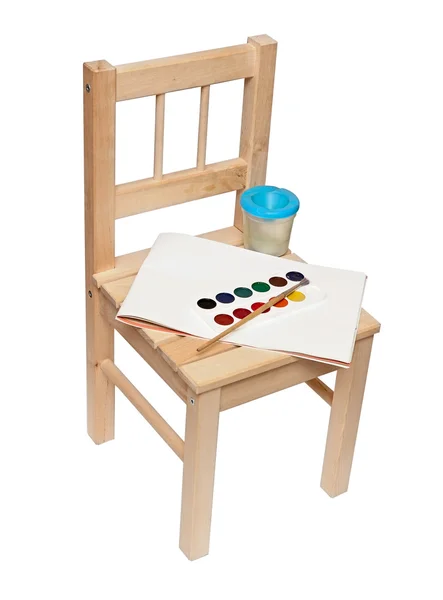Une petite chaise en bois avec des peintures et des pinceaux pour peindre isolée — Photo