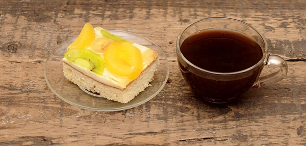 Close-up van glas kopje koffie en abrikoos taart op houten tafel — Stockfoto