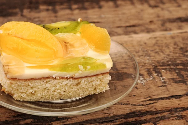 Gros plan du gâteau à l'abricot sur une assiette en verre sur une table en bois — Photo