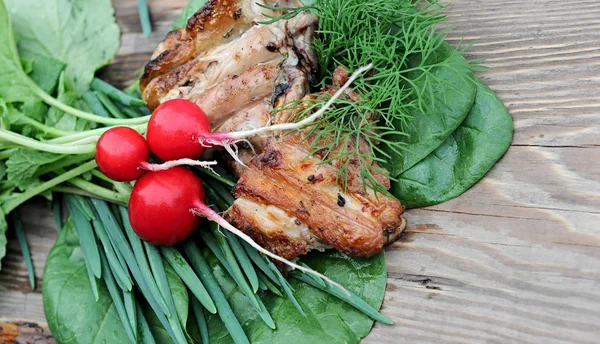 Pollo a la parrilla con cebolla, rábano y espinacas sobre mesa de madera —  Fotos de Stock