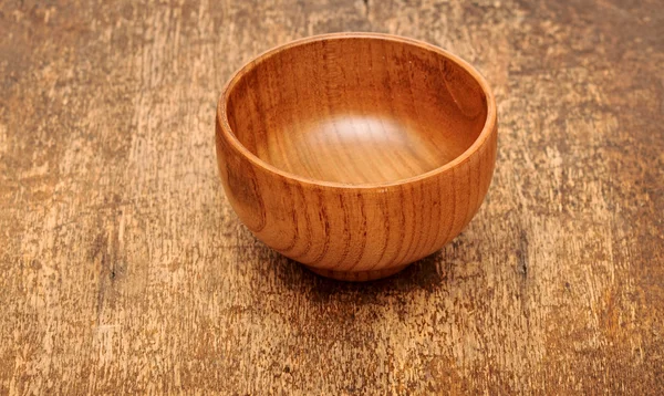 Деревянная чаша на деревянном столе — стоковое фото