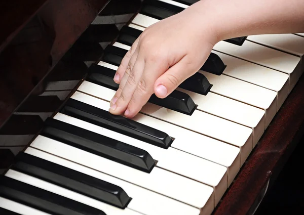 Mãos de criança tocando um teclado de piano — Fotografia de Stock