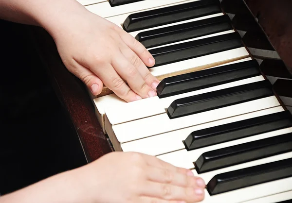 Children 's hands playing the piano — стоковое фото