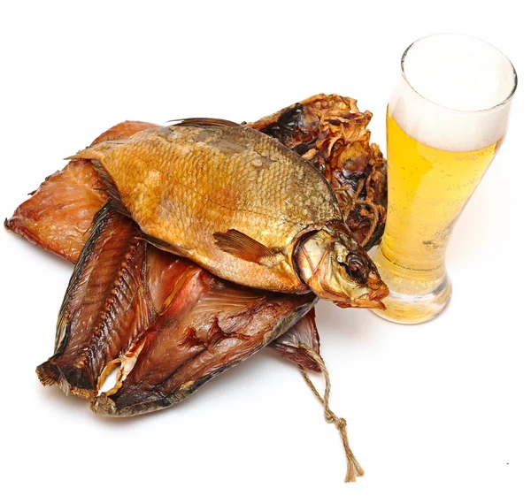 Pilha de peixe defumado e xícara de cerveja em um fundo branco — Fotografia de Stock