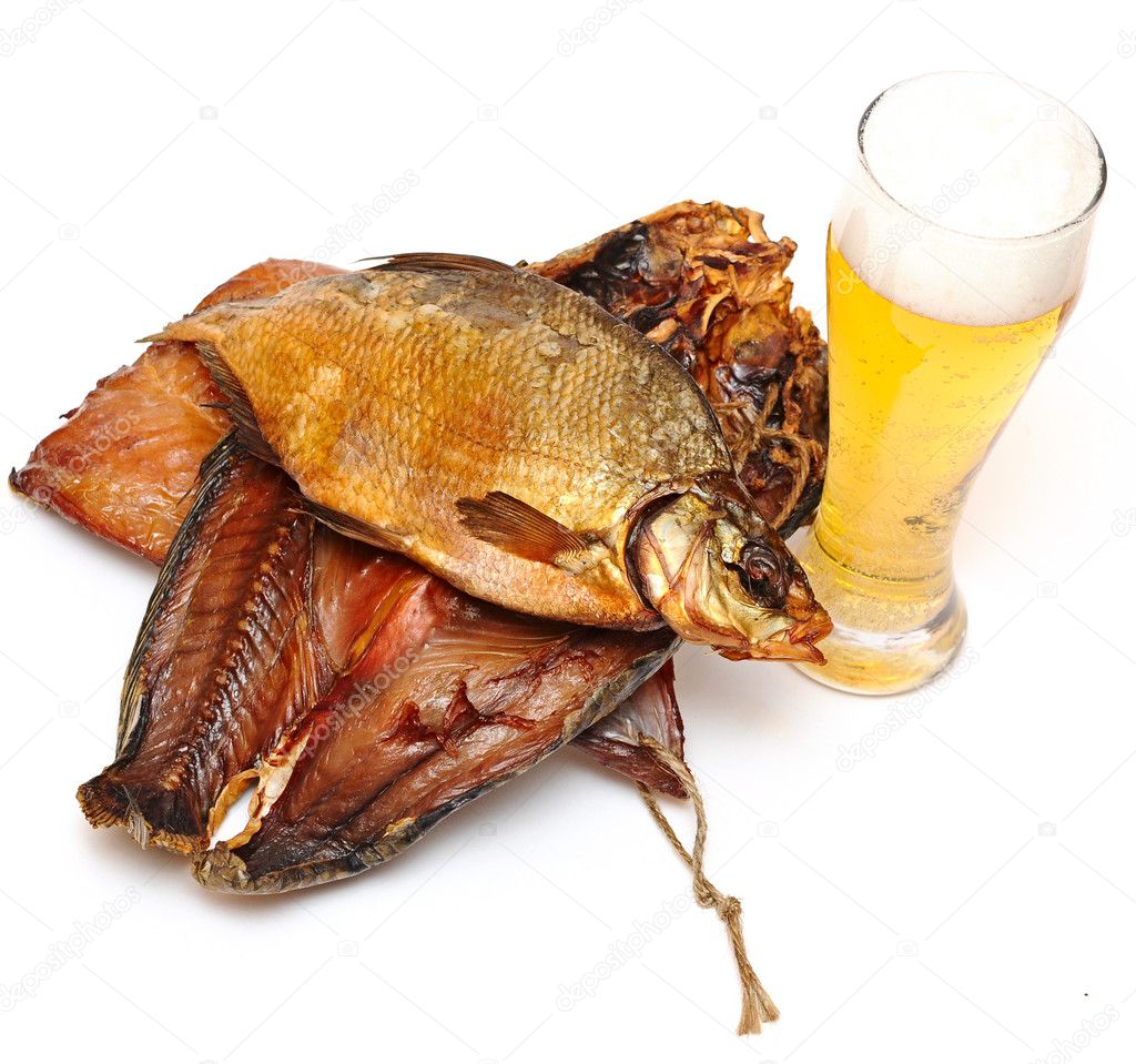 Pile smoked fish and cup of beer on a white background