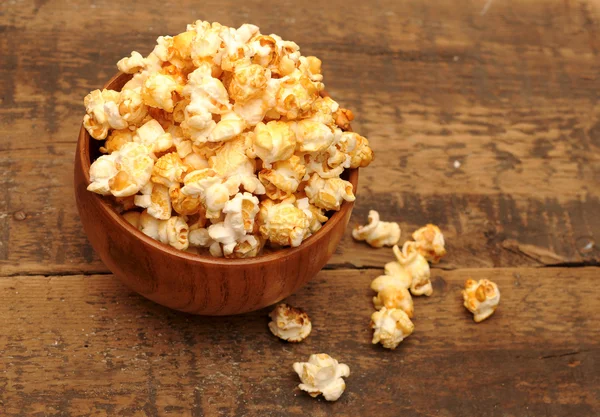 Popcorn w brązowy Puchar na drewnianym stole — Zdjęcie stockowe