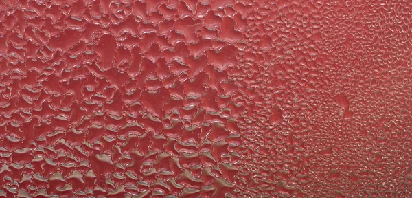 Gotas de água na superfície vermelha abstrata. — Fotografia de Stock