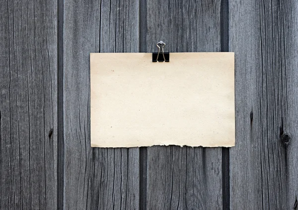 Zwart fragment en oud lege nota papier hangen op houten paneel — Stockfoto