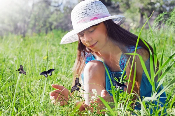 Dziewczyna wręczył łapie motyle w słoneczny dzień — Zdjęcie stockowe