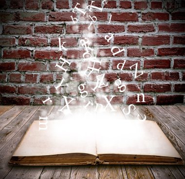 An open book with letters falling into the pages clipart