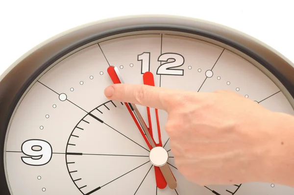 Reloj de pared mostrando cinco minutos a las doce y una mano trayendo ar — Foto de Stock