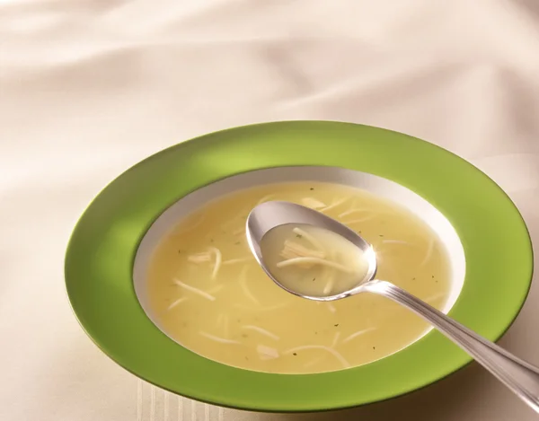 Горячий куриный суп на зеленой тарелке — стоковое фото