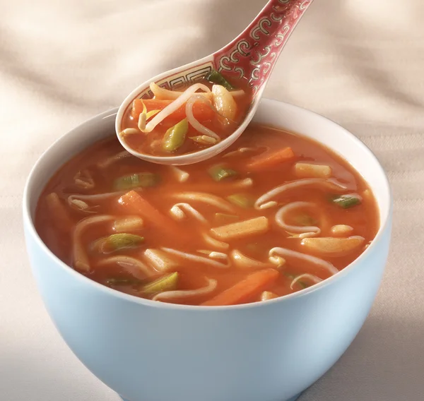 中華スープと伝統的なスプーン hoveri テーブルの上にボウルします。 ストック画像