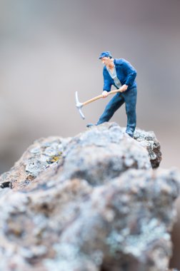 Figure of miner with pickaxe at work. clipart
