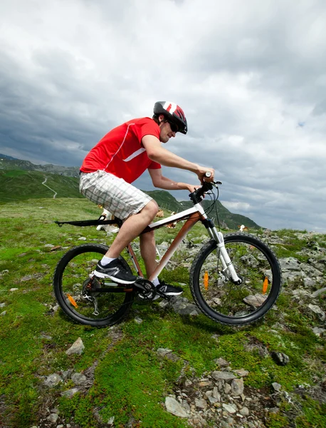 Um homem montando uma bicicleta de montanha — Fotografia de Stock