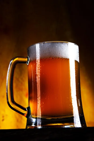Bier in een glas met gouden achtergrond — Stockfoto