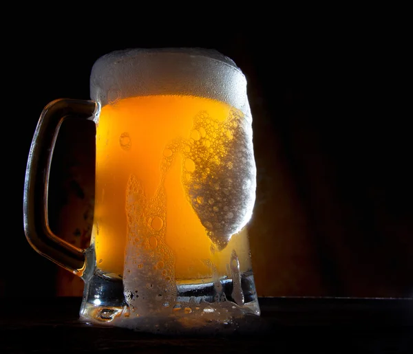 Birra in un bicchiere con fondo oro — Foto Stock